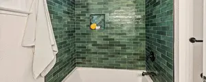 Tub surround with green tiles.