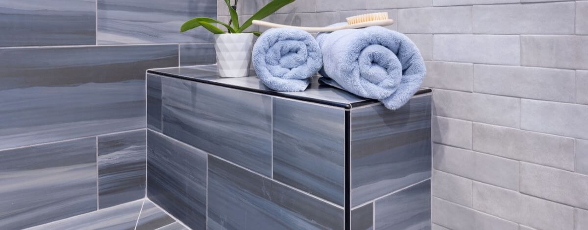 Shower bench with 12x24 inch blue colorway porcelain tiles.