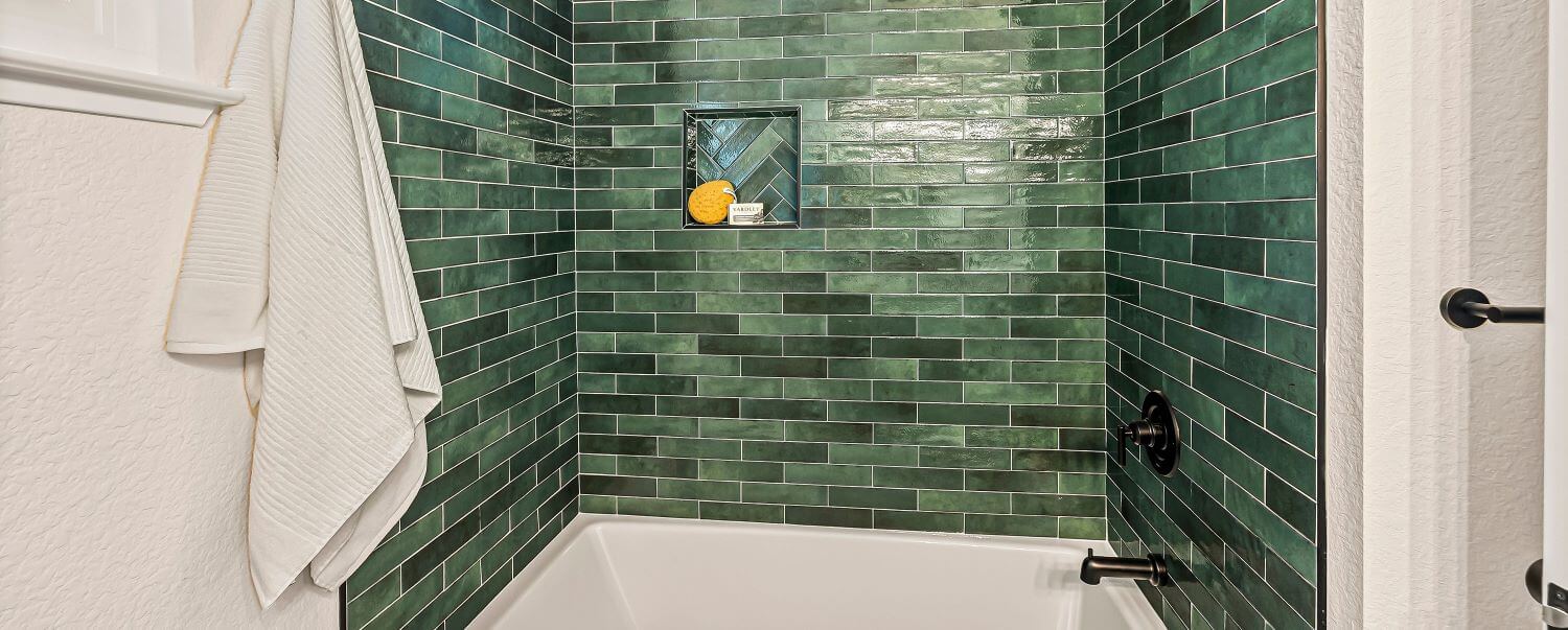 Tub surround with green tiles.